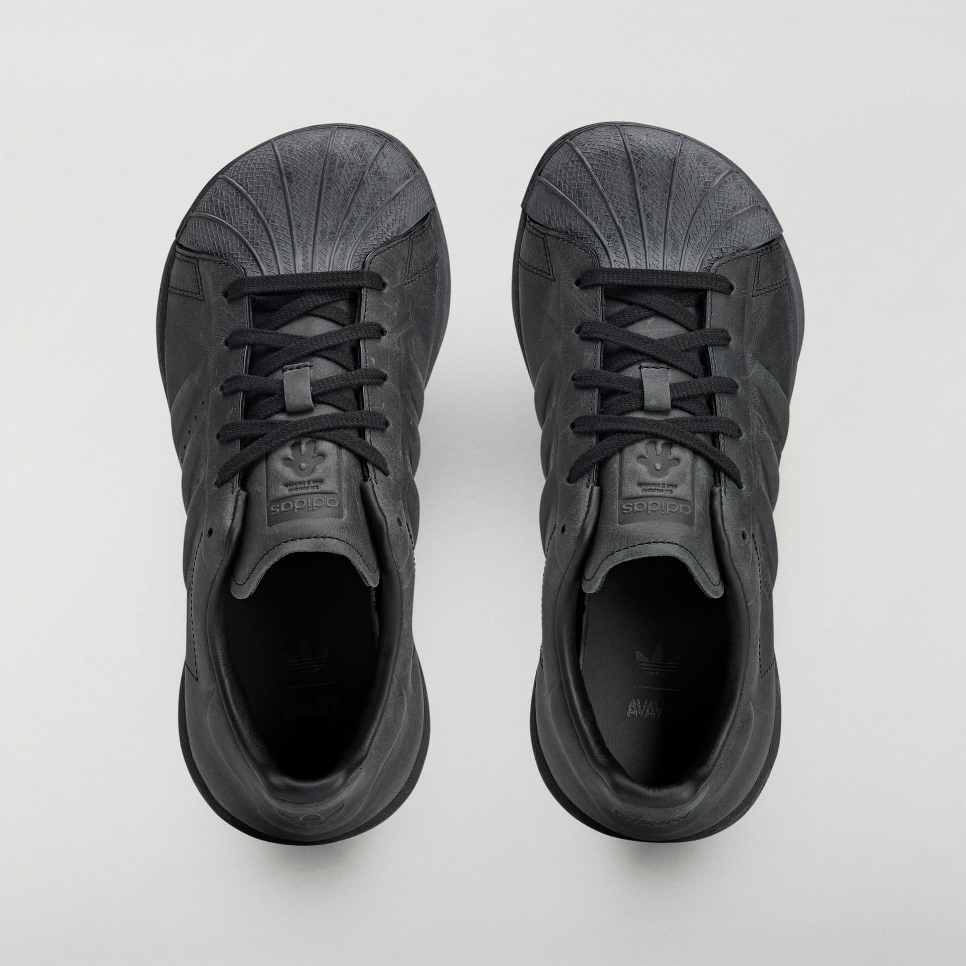 Top-down view of the all-black adidas Originals by Avavav Modified Superstar shoes, showing the leather upper and shell-toe.