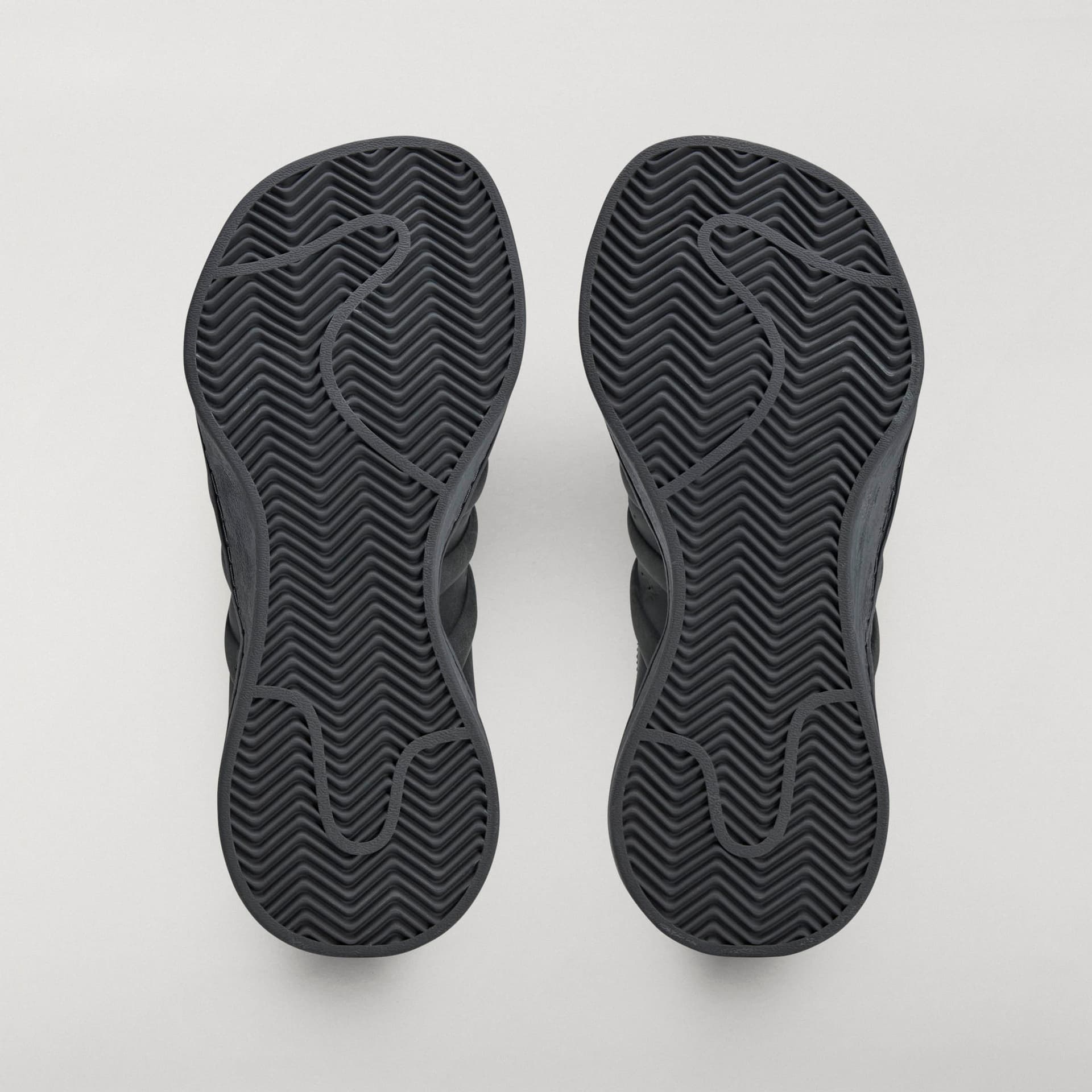 Bottom view of the black adidas Originals by Avavav Modified Superstar sneakers, showing herringbone pattern on the soles.