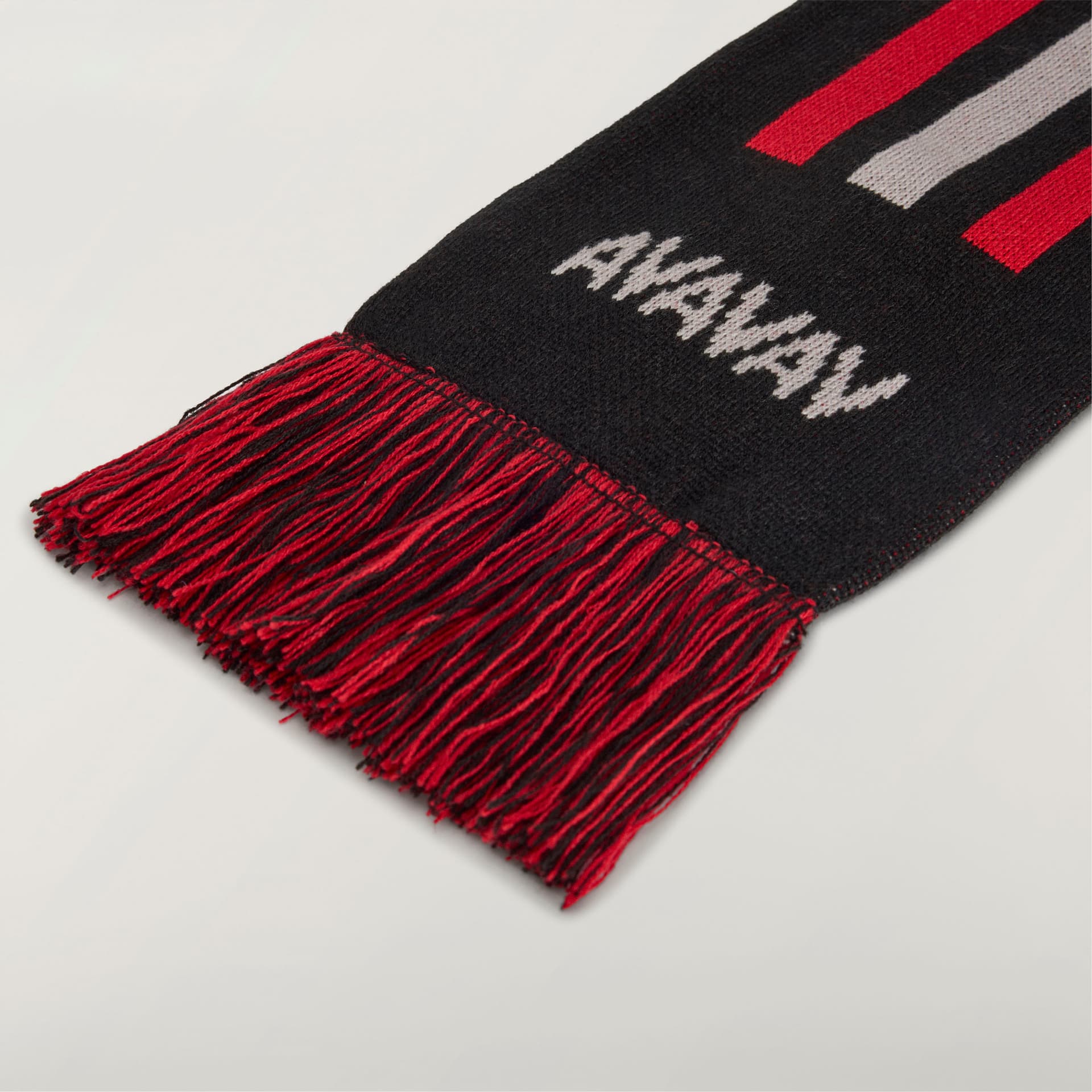 A detail shot of the adidas Originals by Avavav Scarf, showing the black knit, white brand logo, and red fringe.