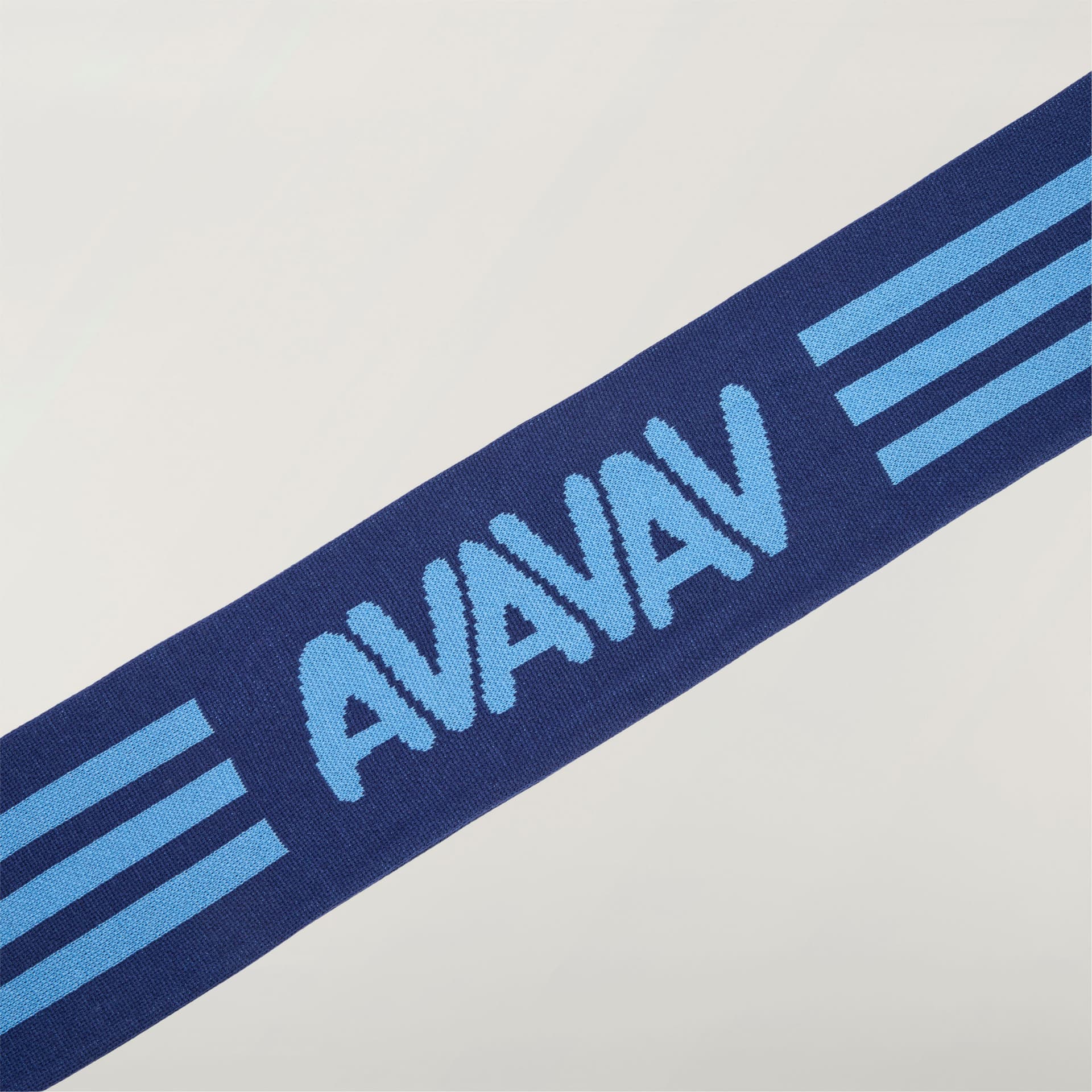 A close-up of the blue adidas Originals by Avavav Scarf, showing the light blue AVAVAV logo and three-stripe design.